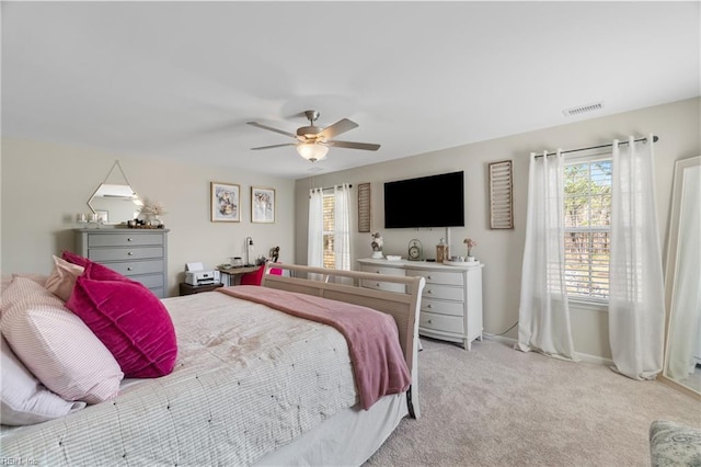 bedroom with visible vents, a ceiling fan, baseboards, and light carpet