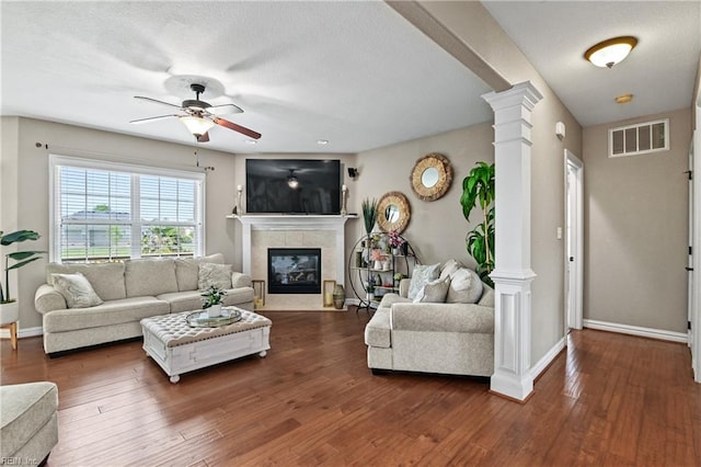 living area featuring visible vents, baseboards, ceiling fan, and decorative columns