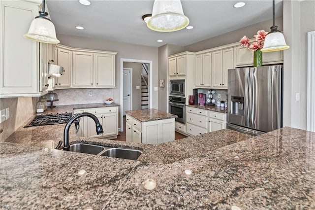 kitchen with ventilation hood, dark stone countertops, backsplash, a sink, and appliances with stainless steel finishes