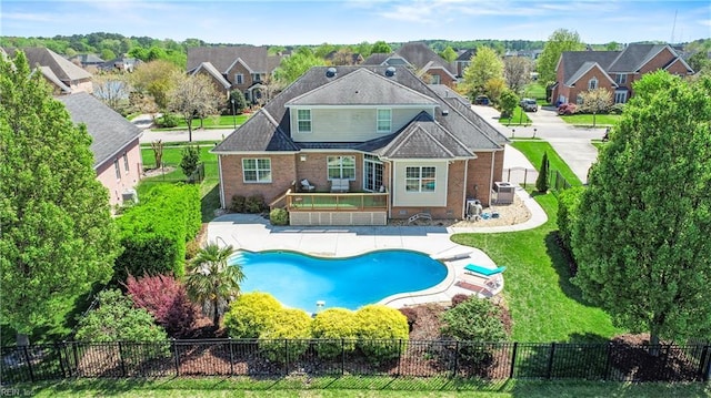 back of property with a fenced backyard, a fenced in pool, a residential view, and a patio