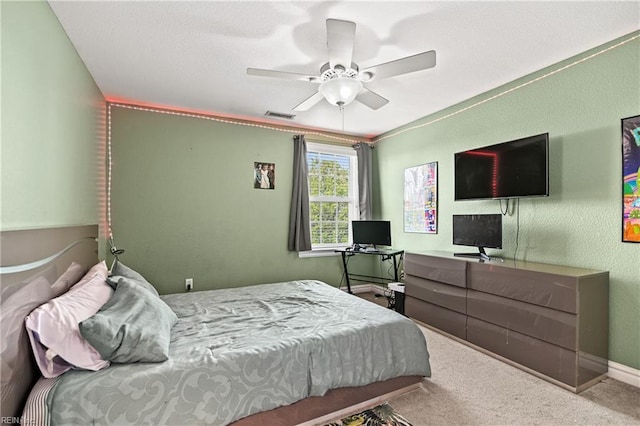 carpeted bedroom with visible vents, baseboards, and ceiling fan