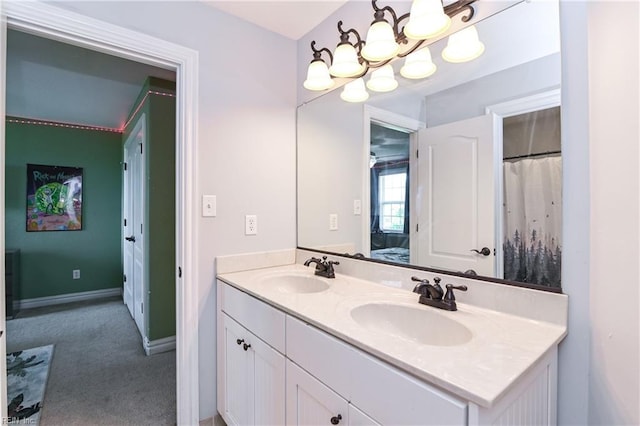 bathroom with a chandelier, a sink, double vanity, and ensuite bathroom