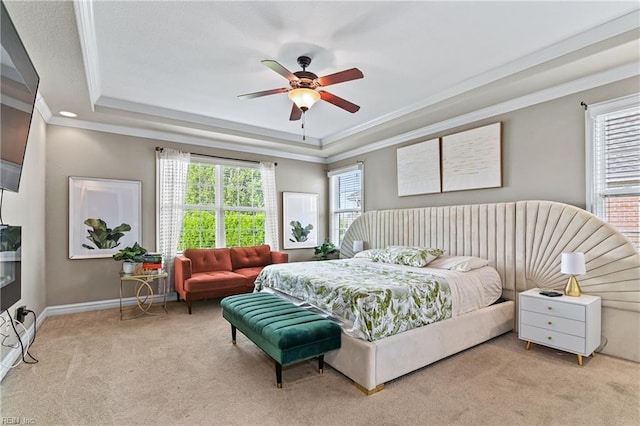 carpeted bedroom with ceiling fan, baseboards, a raised ceiling, and crown molding