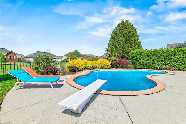 view of swimming pool featuring fence, a diving board, a patio, a fenced in pool, and a residential view