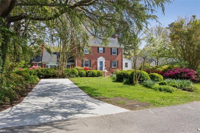 24 Holly Dr, Newport News, VA 23601 - colonial house with a front lawn, a chimney, and concrete driveway