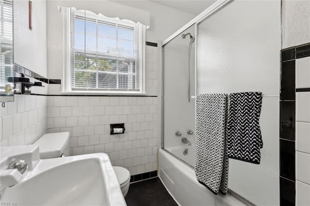24 Holly Dr, Newport News, VA 23601 - bathroom featuring a wainscoted wall, a sink, bath / shower combo with glass door, toilet, and tile walls