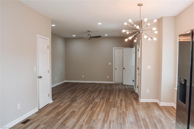 404 Hogart St, Franklin, VA 23851 - spare room featuring baseboards, light wood finished floors, and ceiling fan with notable chandelier