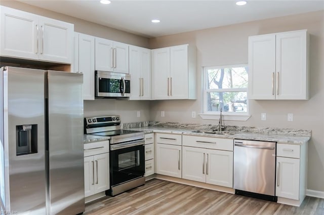 404 Hogart St, Franklin, VA 23851 - kitchen featuring light wood-style floors, a sink, white cabinetry, and appliances with stainless steel finishes