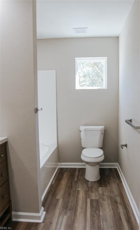 404 Hogart St, Franklin, VA 23851 - full bath with a bath, toilet, baseboards, wood finished floors, and vanity