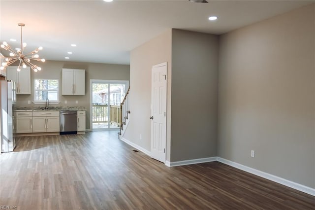 404 Hogart St, Franklin, VA 23851 - unfurnished living room featuring wood finished floors, a sink, baseboards, stairs, and a notable chandelier
