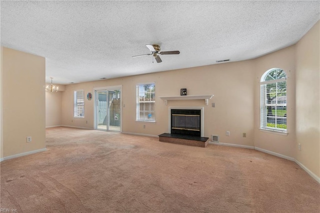 5201 Bardith Cir, Virginia Beach, VA 23455 - unfurnished living room featuring a glass covered fireplace, a chandelier, carpet floors, a ceiling fan, and a textured ceiling