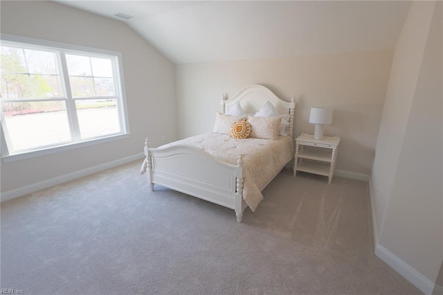 carpeted bedroom with lofted ceiling, visible vents, and baseboards