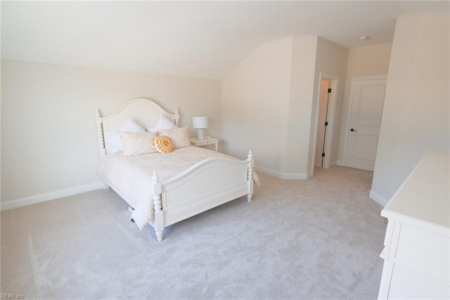 bedroom featuring lofted ceiling, baseboards, and light carpet