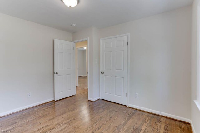unfurnished bedroom with wood finished floors and baseboards