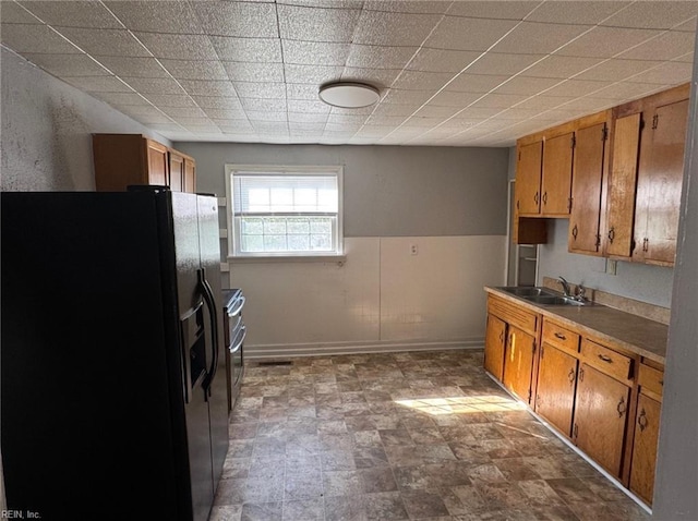 3800 Victoria Blvd, Hampton, VA 23669 - kitchen featuring brown cabinetry, double oven range, a sink, and black fridge