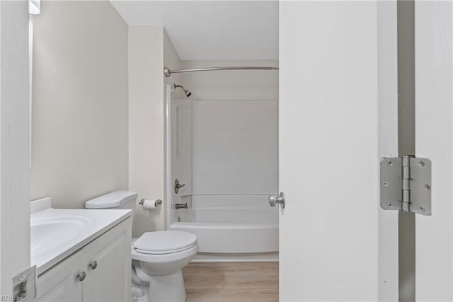 bathroom with toilet, vanity, wood finished floors, and shower / tub combination