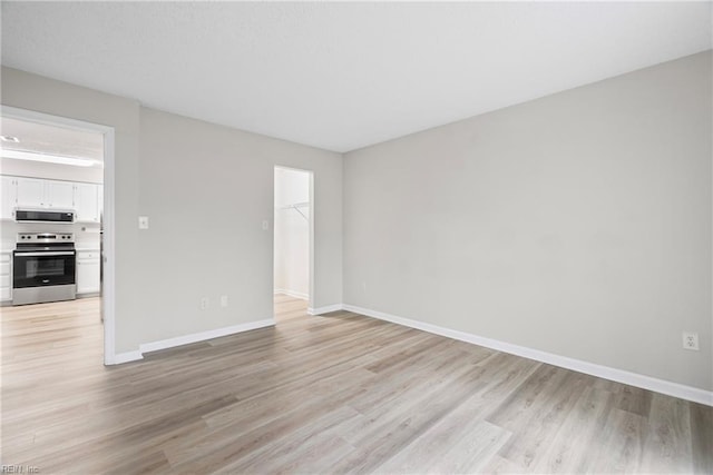 empty room with light wood-style floors and baseboards