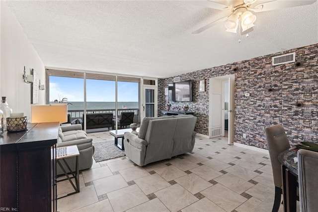 3300 Ocean Shore Ave Unit 503, Virginia Beach, VA 23451 - living area featuring a ceiling fan, a textured ceiling, visible vents, and a wall of windows