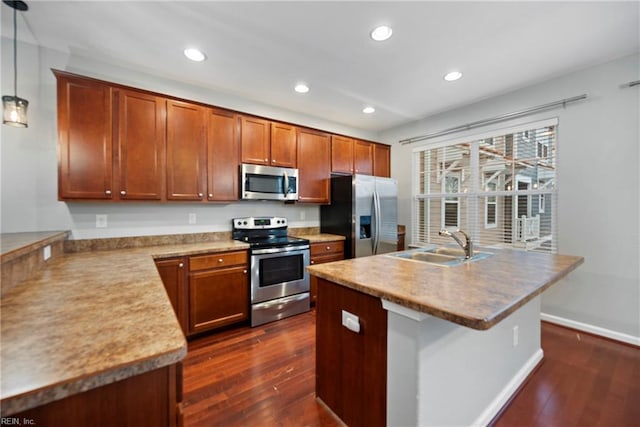 kitchen with dark wood finished floors, appliances with stainless steel finishes, a sink, and recessed lighting