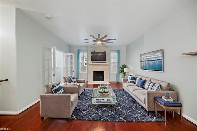 living area featuring french doors, wood finished floors, baseboards, and a large fireplace