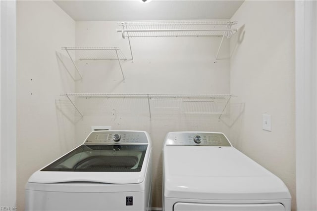 clothes washing area with laundry area and washer and clothes dryer