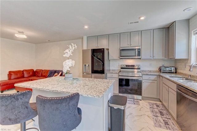 kitchen featuring a sink, visible vents, gray cabinetry, marble finish floor, and appliances with stainless steel finishes