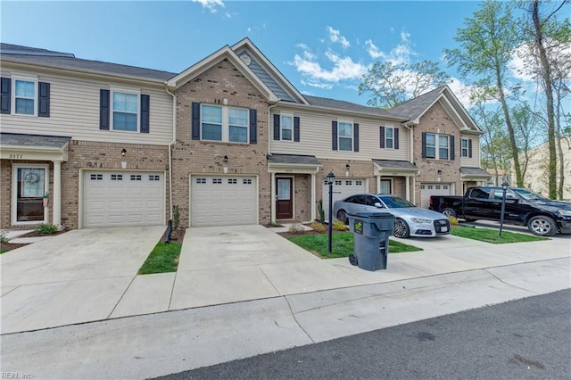 view of front of house with an attached garage, driveway, and brick siding