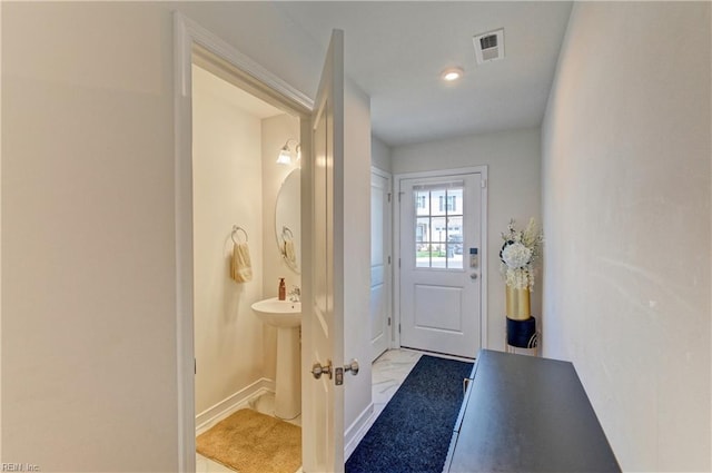 doorway to outside with baseboards, visible vents, and light tile patterned floors