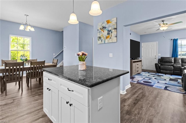 kitchen featuring light wood-type flooring, a center island, a wealth of natural light, and ceiling fan with notable chandelier