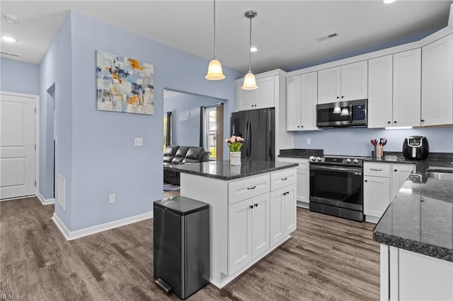 kitchen with dark wood finished floors, appliances with stainless steel finishes, visible vents, and white cabinets