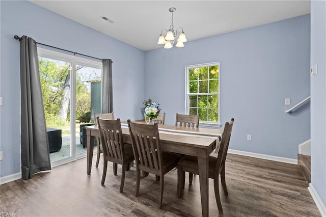 dining room featuring wood finished floors, visible vents, baseboards, and an inviting chandelier