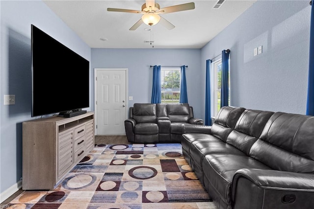 living area featuring ceiling fan, light wood-style floors, and visible vents