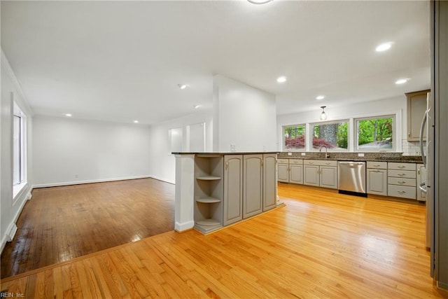 kitchen with open shelves, dark countertops, stainless steel dishwasher, a sink, and light wood-style floors