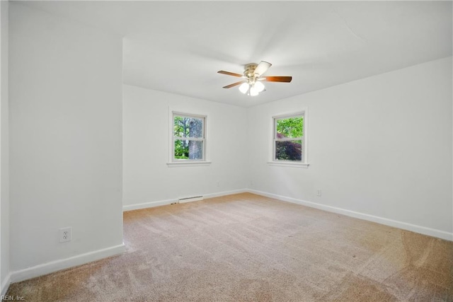 spare room with baseboards, a ceiling fan, carpet flooring, and a wealth of natural light