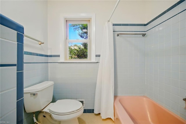 full bath featuring a wainscoted wall, tile patterned floors, toilet, tile walls, and shower / tub combo