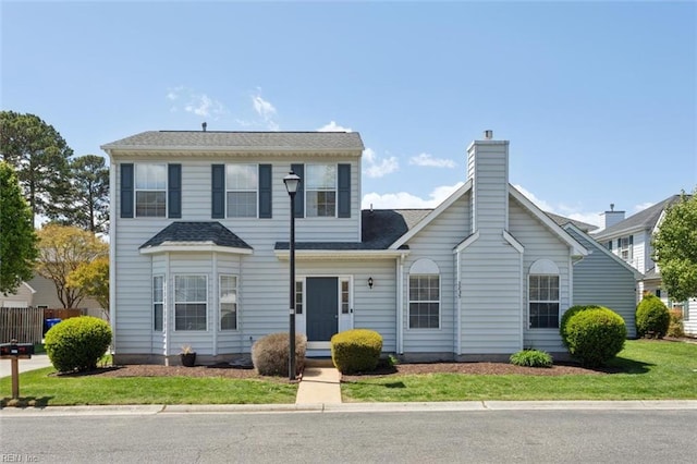view of front of house featuring a chimney and a shingled roof