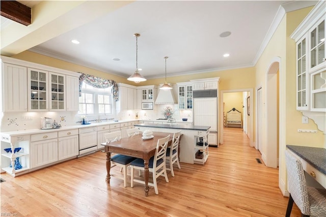 kitchen featuring crown molding, white dishwasher, paneled built in refrigerator, and light wood-style flooring