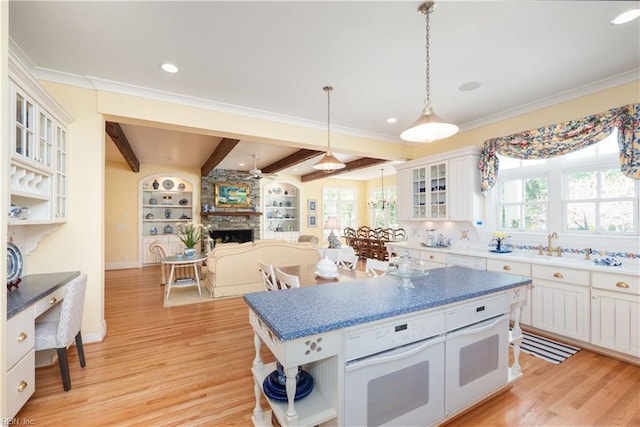 kitchen featuring open shelves, oven, beamed ceiling, light wood-style flooring, and white cabinets