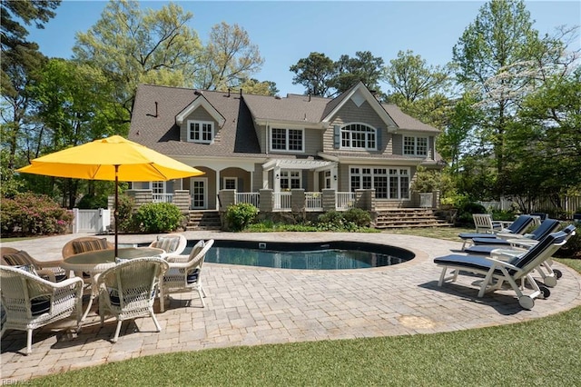 view of pool with fence, a wooden deck, a fenced in pool, and a patio area