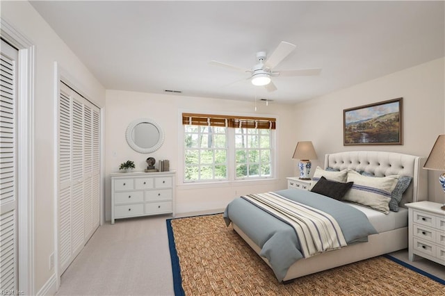 bedroom with light colored carpet, ceiling fan, baseboards, and visible vents