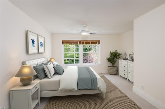 bedroom featuring light carpet, baseboards, and ceiling fan