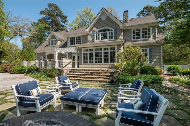 rear view of property with a patio area, a chimney, and an outdoor living space