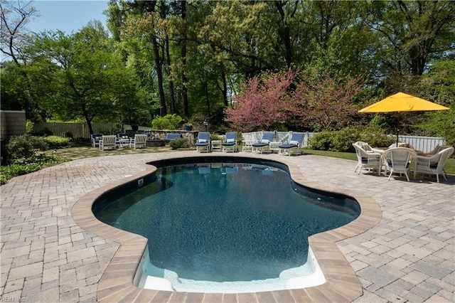 view of pool with fence, a patio area, a fenced in pool, and outdoor dining space