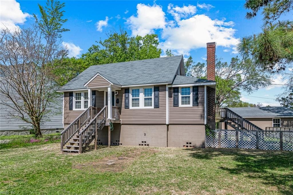 view of front of property with stairway, a chimney, and a front yard