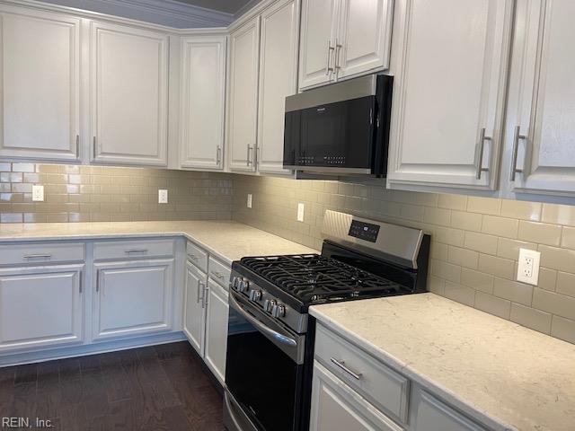 kitchen featuring white cabinets, dark wood finished floors, tasteful backsplash, and stainless steel gas range