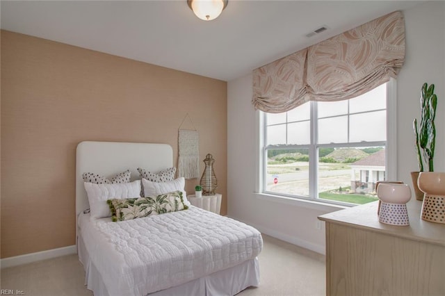 bedroom featuring light carpet and baseboards