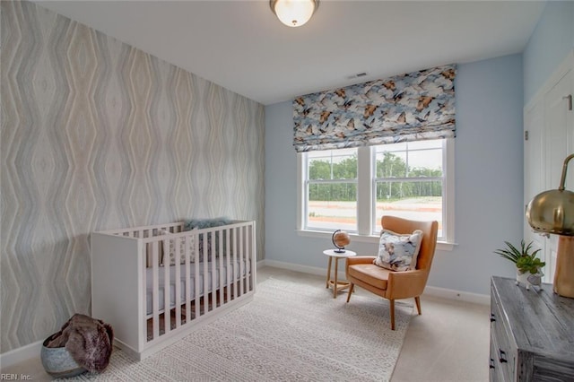 bedroom with wallpapered walls, carpet floors, visible vents, and baseboards