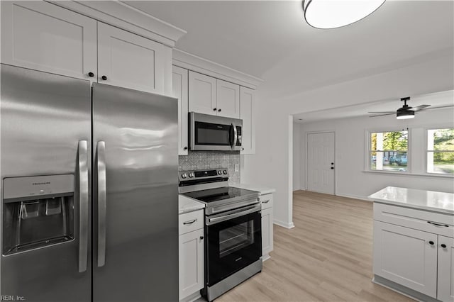 kitchen with light wood-style flooring, appliances with stainless steel finishes, tasteful backsplash, and light countertops
