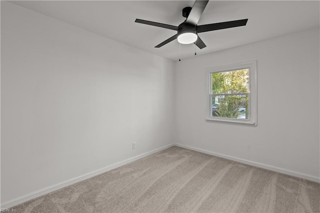 spare room featuring carpet floors, a ceiling fan, and baseboards