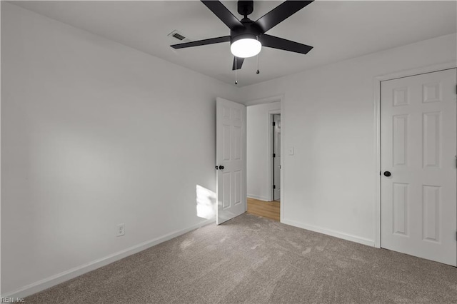 unfurnished bedroom with carpet floors, visible vents, baseboards, and ceiling fan